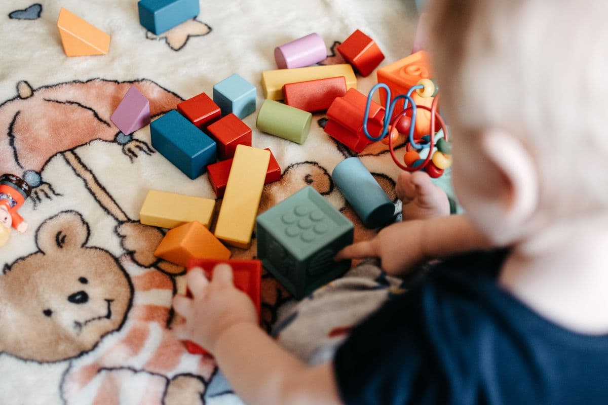 Un peque juega con bloques de construcción de colores