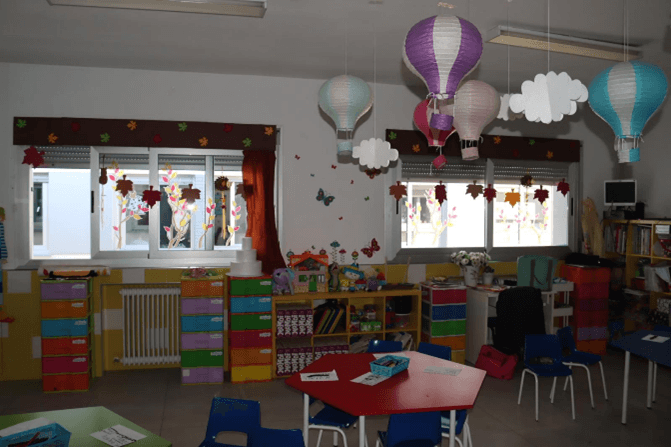 Rincón de juego y estanterías de colores en un aula de Infantil del colegio